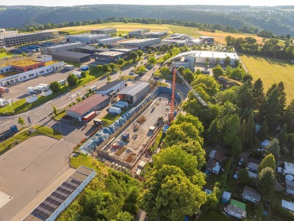 Aerial view of an industrial site with major construction site activities, adjacent to fields and
