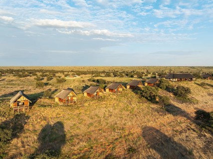 The Ta Shebube Rooiputs Lodge in the Kalahari Desert during the rainy season with green vegetation.