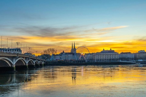 Bayonne cityscape along the adour river at christmas, featuring a illuminated ferris wheel,