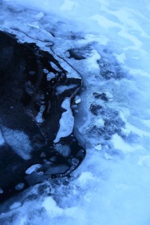 Frozen surface structure with visible cracks and glacier ice, air bubbles trapped in the ice of a