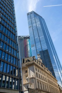 Glass facade of 22 Bishopsgate skyscraper rising above historic building stone architecture, City