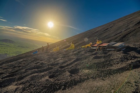 Tourists sandboarding on Cerro Negro, Leon, Nicaragua. Group of adventurers sandboarding down a