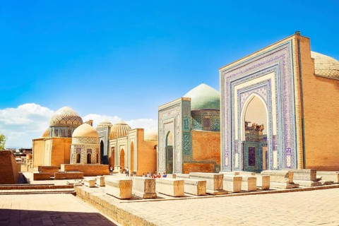 Cinematic Shah i Zinda necropolis in Samarkand. Visitors explore the stunning blue-tiled mausoleums