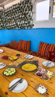 Spread of moroccan breakfast dishes. Including omelette. Flatbread. Olives. Cucumber. Jam. And