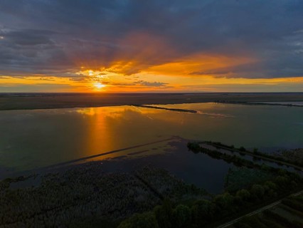 Impressive sunset over a lake with bright colors and reflections, aerial view, Hortobágyi Halastó,