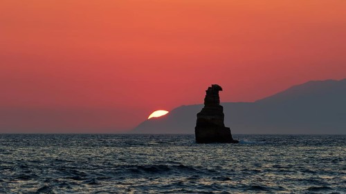 Dramatic sunset over the sea with a rock in the foreground in a calm atmosphere, sunset, south of