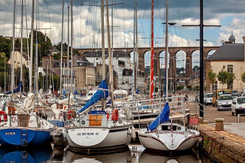 Quiet harbor with sailboats and bridge in the background of a historic town, The port of Morlaix in