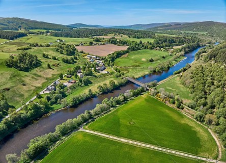 Aerial drone view of the forest and pasture landscape at Spey River in eastern Scotland, UK