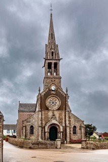 Historic Gothic-style church with high tower and clock under cloudy sky, The Église Notre-Dame de