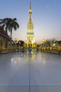 Chedi decorated with golden ornaments at Wat Phra That Phanom at sunset, temple complex in Amphoe