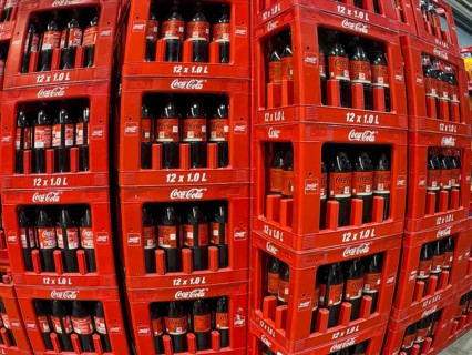 Perspective dynamically deformed photo of left column stacked in boxes 1 liter PET bottles