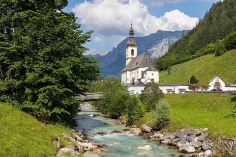 Famous view of the parish church of St. Sebastian with bridge over the Ramsauer Ache in the