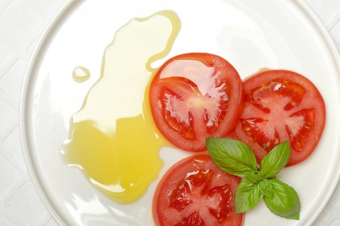 Sliced tomatoes on plate with olive oil
