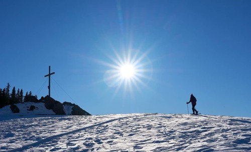 Nice and active senior woman snowshoeing in in the Allgau alps above Immenstadt, Bavaria, Germany