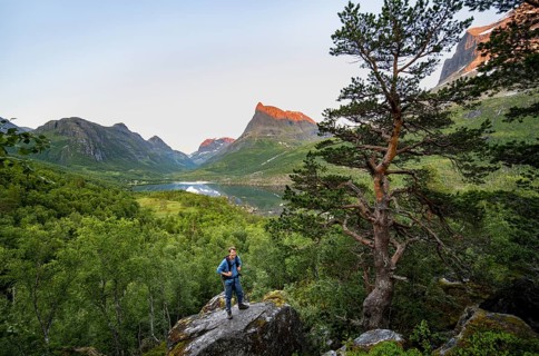 Young man in front of picturesque Innerdalen high valley with lake Innerdalsvatna, mountains with