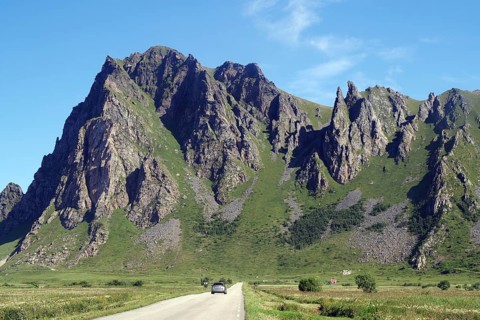 Impressive mountain landscape with steep rock formation next to a country road, Bleik, Andøya,