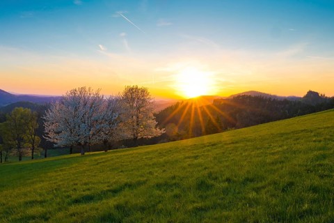 View of Ružák, Rosenberg, across the spring-like Bohemian Switzerland with blooming fruit trees,
