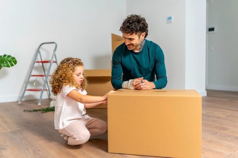 Family moving into new apartment, father and daughter unpacking belongings, creating new memories