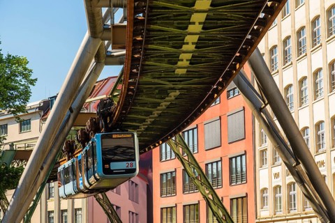 A suspension railway runs between old industrial buildings near the Kluse stop, Wuppertal, Germany
