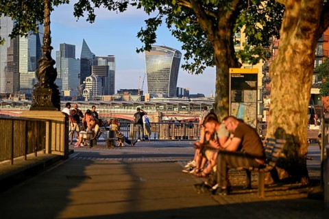 Waterfront promenade on the Thames, in the background the skyline of the City of London with the