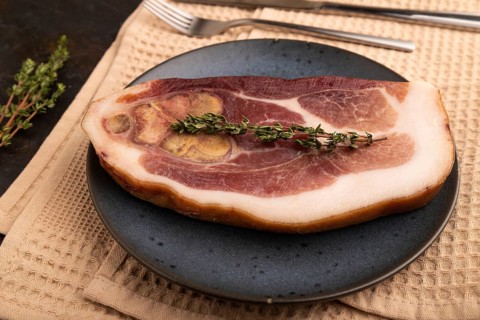 Dry-aged steak, Pork ham with thyme on black concrete background and beige linen textile. side