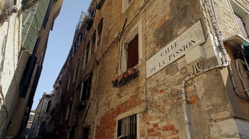 Narrow alley in Venice, alleyway sign 'Calle de la Passion' with old brick architecture and flower