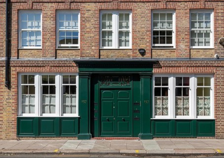 Brick building with large windows and a distinctive green entrance door, Royal Borough of