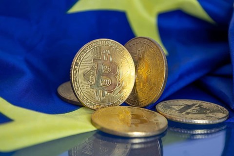 Close-up of symbolic bitcoins with an EU flag