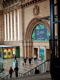 Historic station entrance with eye-catching arch detail and people, train station, Leipzig main