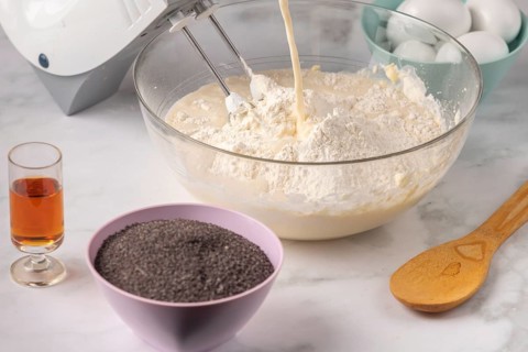 Milk is poured into a bowl with other ingredients for dough