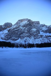 Quiet winter landscape with snow-covered mountains and frozen lake in cold light, Pragser Wildsee,
