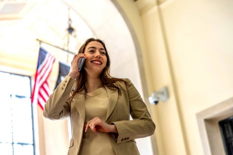 Professional young businesswoman smiling and engaging in an important phone conversation,