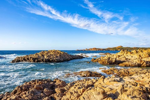 Landscape of the coastline with blue water at Marinedda Coast on a sunny day, Sardinia, Italy