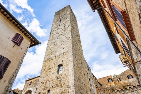 Tower of the old town with historic buildings at San Gimignano on a sunny day, Tuscany, UNESCO