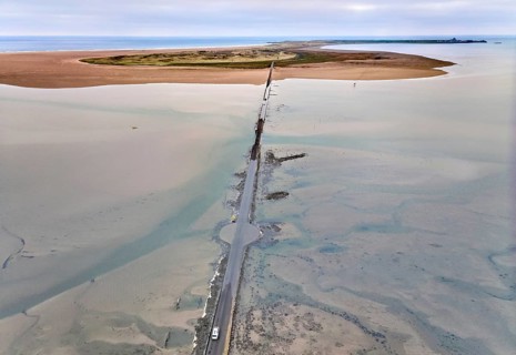 Aerial drone photograph of the causeway with floated road leading to Holy Island and Lindisfarne,