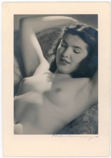 Nude, young woman in the sun, woman lying relaxed with smiling facial expression, appears calm and