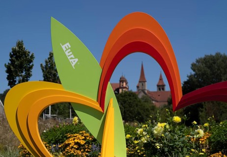 EurA AG logo on a symbol, a sculpture of a flower, with the Protestant Town Church and the