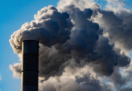 Smoke flows from a factory chimney against a blue sky, air pollution, industry, climate protection,
