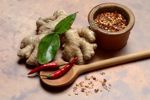 Ginger, ginger root with kaffir lime leaf and chili pepper and chilli flakes in pot