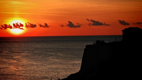 Sunset over sea with silhouette of cliffs and orange sky, Ulcinj, Montenegro