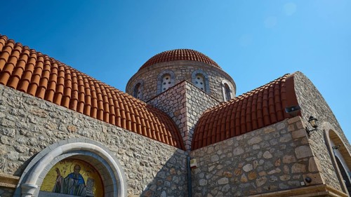 Agiou Sarvas monastery, Agion Pandon church, stone church with dome and mosaic under blue sky,