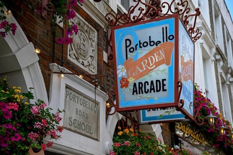 Detailed view of Portobello Garden Arcade entrance sign with floral decoration, Portobello Road,