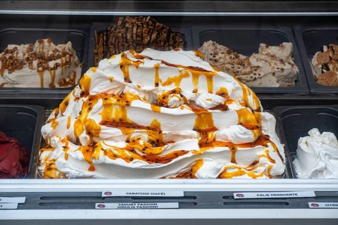 Accumulated ice cream coated with caramel sauce in an ice cream display case at an ice cream