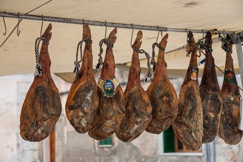 Sales stand with whole pork ham, farmers market, weekly market market, Sineu, Majorca, Spain