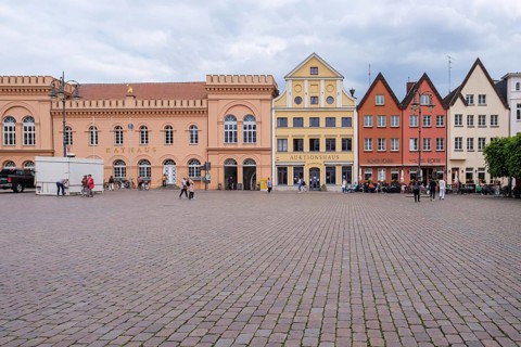 Historic square with colorful buildings and cobblestones surrounded by clouds, Schwerin Old Town,