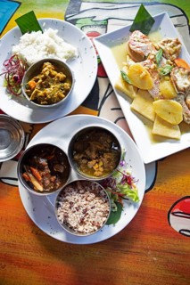Traditional Jamaican dishes, front oxtail and goat meat, left curry chicken, right cooked northern