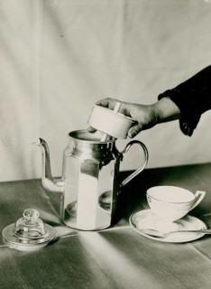 Coffee, Italian espresso pot, advertising, a strainer is held by a hand over a shiny teapot, next