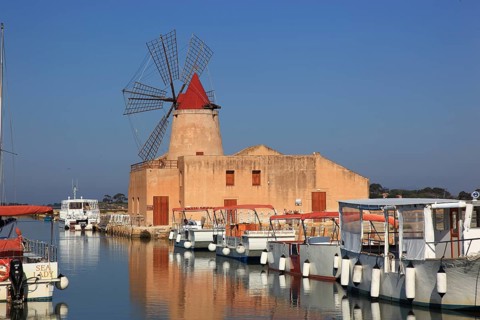Sicily, windmill and boats at the Mozia saltworks near Marsala, Italy