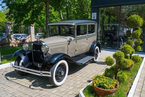 Grey retro car on garden path with green vegetation and sun in the background, classic car, Ford