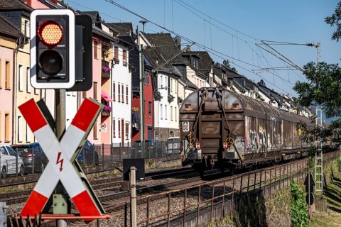 Level crossing, freight train passing through town in Lorchhausen, right next to the residential